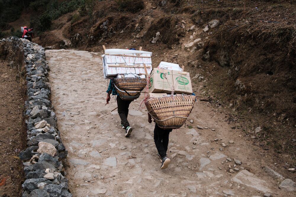 Porters carrying baskets and boxes on their back
